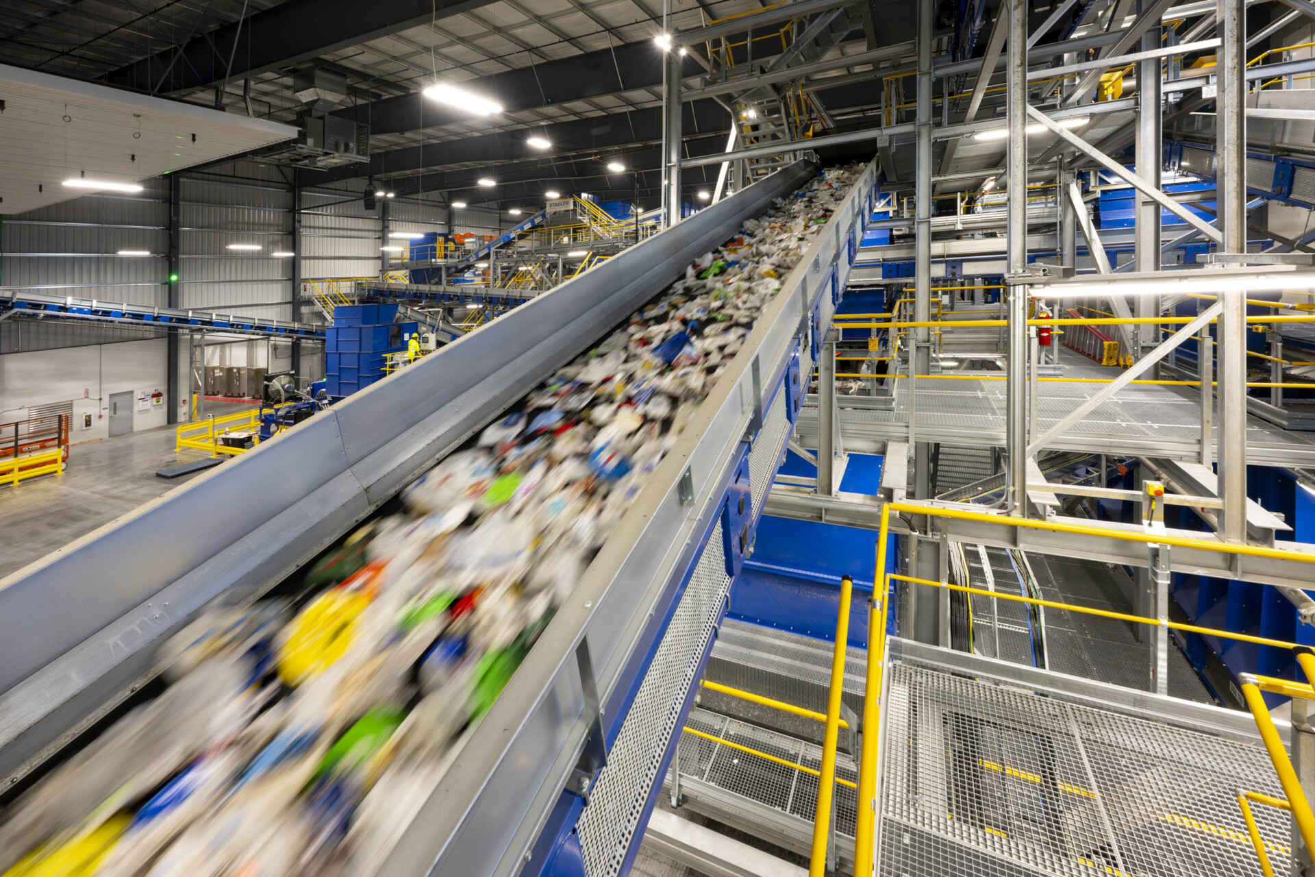 Sorting conveyor carrying mixed plastic packaging through a modern recycling plant