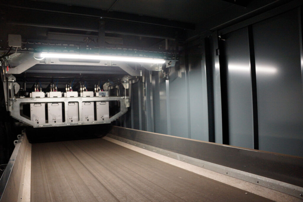 Interior of a Cleansort sorting system showing a row of laser measuring modules mounted above an empty conveyor belt