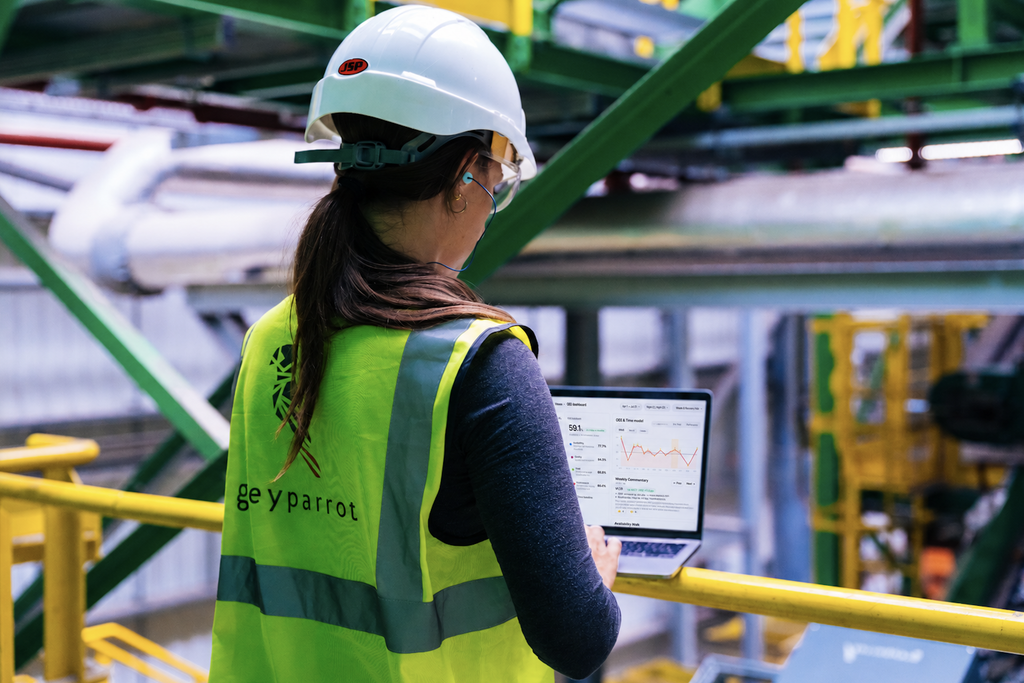 Facility worker reviewing the Greyparrot OEE dashboard on a laptop at a recycling plant