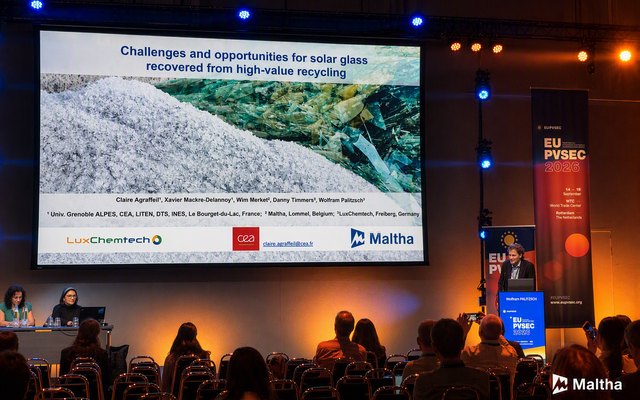 Speaker on stage at EU PVSEC 2026 with a slide on challenges and opportunities for solar glass recovered from high-value recycling