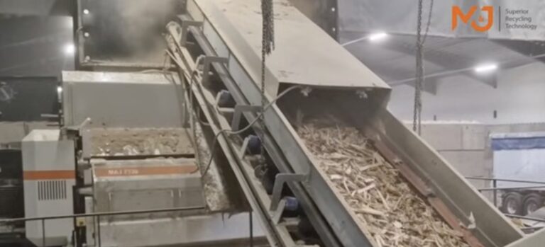 M&J F320e electric fine-shredder in a waste processing hall, with shredded waste wood travelling up an inclined discharge conveyor