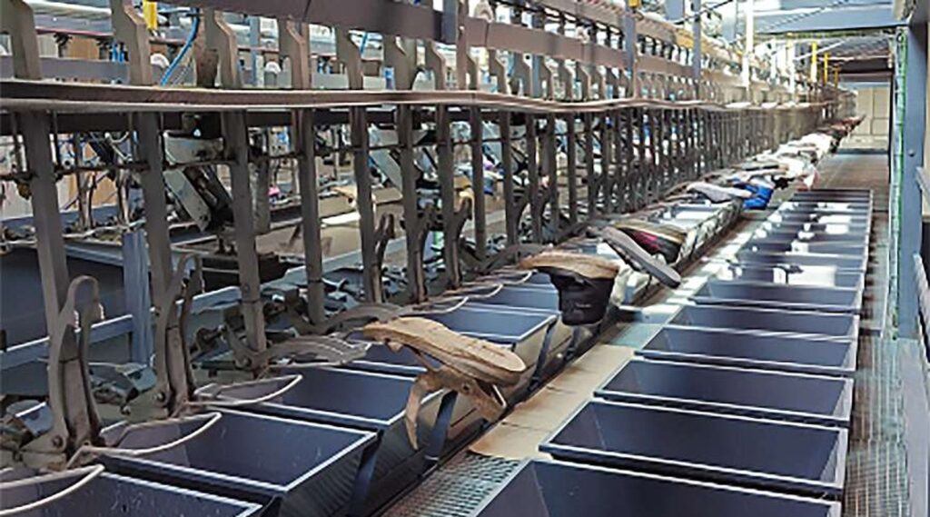 Used shoes travelling on an automated conveyor sorting line in a textile recycling plant