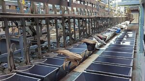 Used shoes travelling on an automated conveyor sorting line in a textile recycling plant