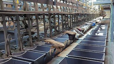 Used shoes travelling on an automated conveyor sorting line in a textile recycling plant