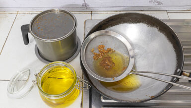 Used cooking oil in a pan and glass jars, collected for recycling into renewable fuel