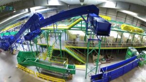 Green and blue conveyors and sorting stations of the Valvan textile sorting system inside the Gebetex Tri Normandie hall