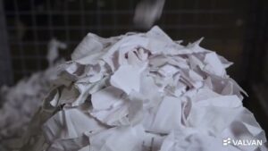 Pile of white pre-cut textile clippings inside the Valvan Trimclean trim removal system